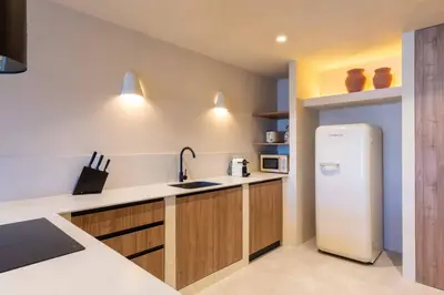 a kitchen with a white refrigerator and wooden cabinets at VLC Host - Reina 166 B in Valencia