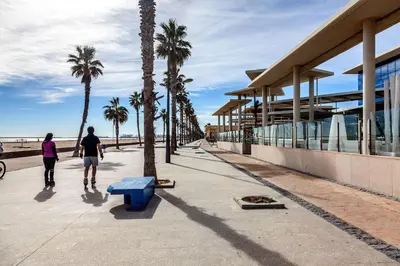 a man and woman rollerblading down a sidewalk near the beach at Apartment Patacona Beach 6 in Valencia