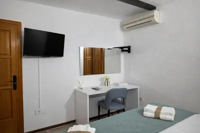 a hotel room with a desk and a bed and a monitor at Mini Peixcateria in Sagunto