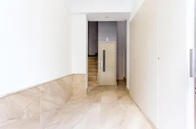 a hallway with white walls and marble floors and a door at Apartment Ruzafa Puerto Rico in Valencia