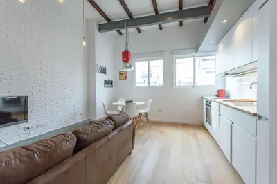 a living room with a brown couch in a kitchen at Apartment Ruzafa Puerto Rico in Valencia