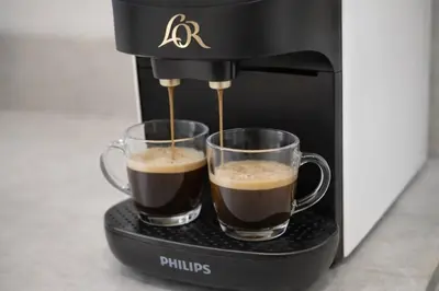 two cups of coffee are being made in a coffee maker at Roig Arena Suite Garden N9 in Valencia
