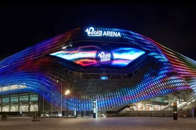 a large building with a colorful facade at night at Roig Arena Suite Garden N9 in Valencia