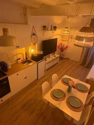 a kitchen and living room with a table and chairs at Las Casitas de Cullera Sol y Mar in Cullera