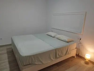 a bed in a room with a white wall at Valencia Room in Cuart de Poblet