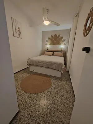 a small bedroom with a bed and a ceiling fan at Maravillosa vistal'mar in Puerto de Sagunto
