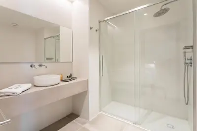 a bathroom with a glass shower and a sink at Valencia Home Alfahuir in Valencia