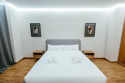 a bedroom with a white bed and two pictures on the wall at Apt Almas, City Hall 1 Min, 4 Pax, Smart Tv in Valencia