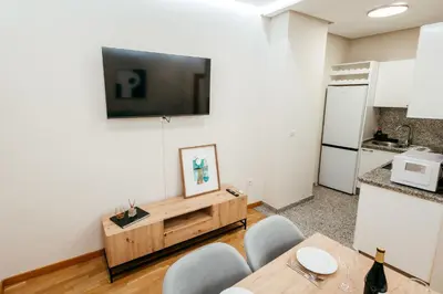 a living room with a table and a television on a wall at Apt Almas, City Hall 1 Min, 4 Pax, Smart Tv in Valencia