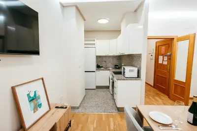 a kitchen with white appliances and a wooden table at Apt Almas, City Hall 1 Min, 4 Pax, Smart Tv in Valencia