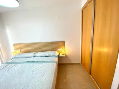 a small bedroom with a bed and a wooden headboard at Dream Moncofar in Moncófar