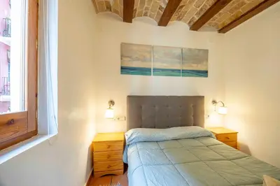 a bedroom with a bed and a painting on the wall at Valencia Flat Rental 1 bedroom apartment historical center in Valencia