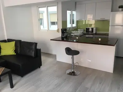 a kitchen with a counter and a chair in a room at Bienvenido a Lovely Apartment, Cullera in Cullera
