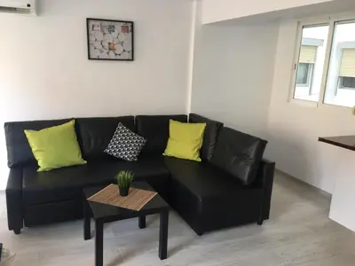 a black leather couch in a living room with a table at Bienvenido a Lovely Apartment, Cullera in Cullera