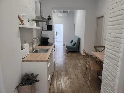 a kitchen and living room with a table and a couch at Pinedo Playa Holiday in Valencia