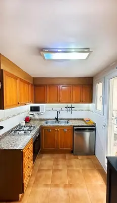 a kitchen with wooden cabinets and a stove top oven at Apartment Monfort in Valencia