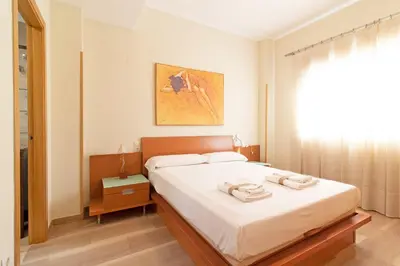 a bedroom with a bed with two towels on it at Global Vacacional, Apartamento con gran terraza en la playa de Puerto Sagunto in Puerto de Sagunto
