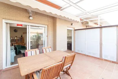 a dining room with a wooden table and chairs at Global Vacacional, Apartamento con gran terraza en la playa de Puerto Sagunto in Puerto de Sagunto