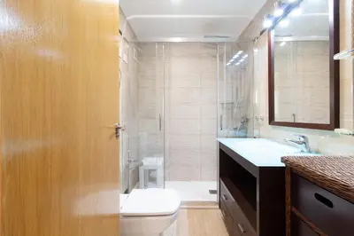 a bathroom with a toilet and a sink and a shower at Global Vacacional, Apartamento con gran terraza en la playa de Puerto Sagunto in Puerto de Sagunto