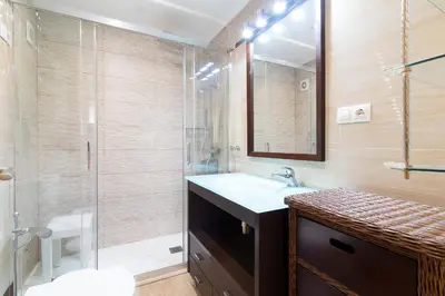 a bathroom with a sink and a glass shower at Global Vacacional, Apartamento con gran terraza en la playa de Puerto Sagunto in Puerto de Sagunto