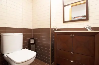 a bathroom with a toilet and a sink and a mirror at Global Vacacional, Apartamento con gran terraza en la playa de Puerto Sagunto in Puerto de Sagunto