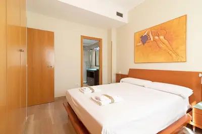 a bedroom with a large white bed in a room at Global Vacacional, Apartamento con gran terraza en la playa de Puerto Sagunto in Puerto de Sagunto