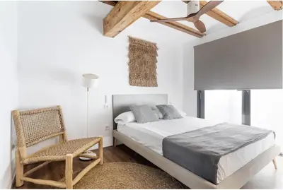 a white bedroom with a bed and a chair at superincreible ubicación in Valencia