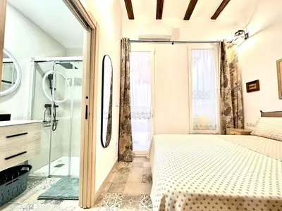 a bathroom with a bed and a glass shower at Season apartment Cabañal in Valencia