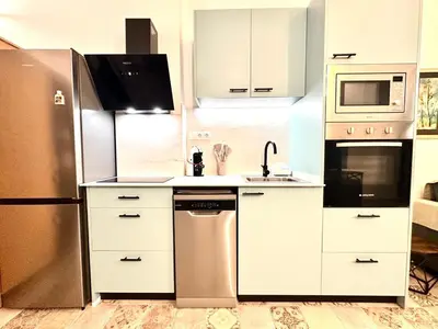 a kitchen with white cabinets and a stainless steel refrigerator at Season apartment Cabañal in Valencia