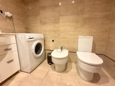 a bathroom with a toilet and a washing machine at Reinapart Patacona Beach Sunrise in Valencia