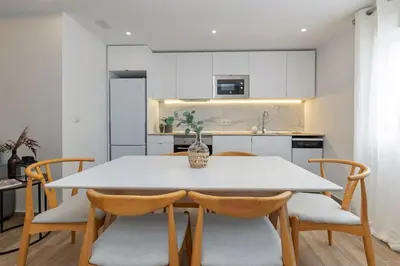 a kitchen and dining room with a white table and chairs at Monte Tulum in Torrent