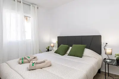 a bedroom with a large white bed with green pillows at Monte Alban Experience a unique place in Torrent