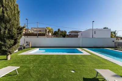 a swimming pool in a yard with a green lawn at Monte Alban Experience a unique place in Torrent