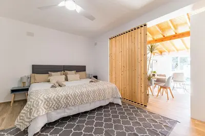 a bedroom with a large bed and a wooden wall at Loft Sayulita Escapada moderna en el paraíso in Torrent