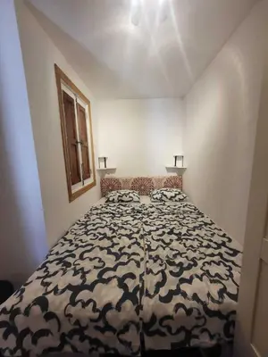 a bedroom with a bed with a black and white comforter at Piso con terraza en Cabanyal in Valencia