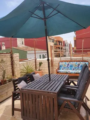 a wooden table with an umbrella on a patio at Piso con terraza en Cabanyal in Valencia