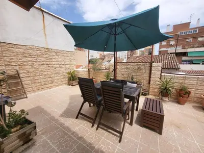 a table and chairs with an umbrella on a patio at Piso con terraza en Cabanyal in Valencia