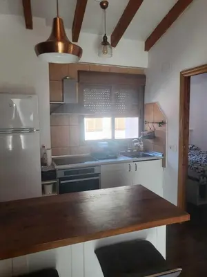 a kitchen with a counter top and a refrigerator at Piso con terraza en Cabanyal in Valencia