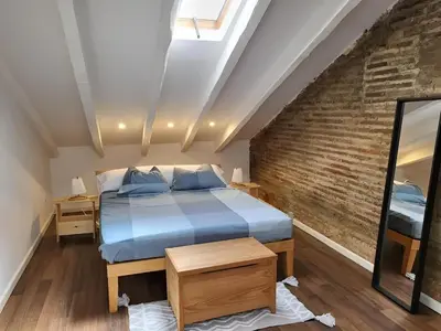 a bedroom with a bed and a brick wall at Precioso apartamento en casa histórica en la playa in Valencia