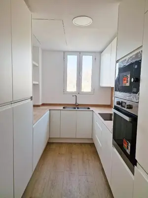a kitchen with white cabinets and a sink at Cabanyal playa las arenas apartamento reformado in Valencia