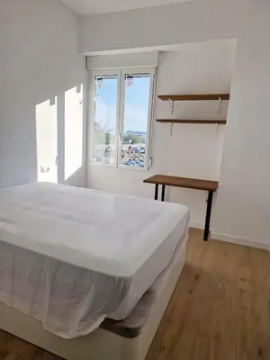 a white bedroom with a large bed and a table at Cabanyal playa las arenas apartamento reformado in Valencia
