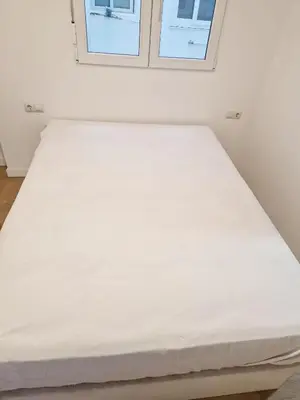 a large white bed in a room with a window at Cabanyal playa las arenas apartamento reformado in Valencia