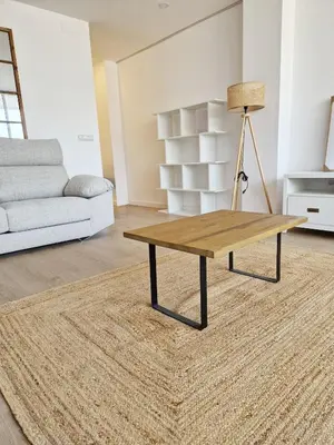 a coffee table in a living room with a couch at Cabanyal playa las arenas apartamento reformado in Valencia