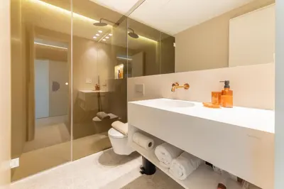 a bathroom with a sink and a toilet and a mirror at GMG Apartments & Suites in Valencia