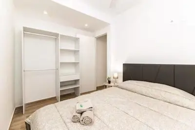 a bedroom with a large white bed with a black headboard at Riviera Esmeralda Relax y belleza en un solo lugar in Torrent