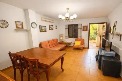 a living room with a table and chairs and a television at Winahost Casita Tavernes de Valldigna in Tavernes de Valldigna