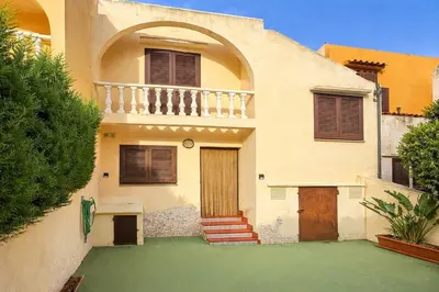 a house with a balcony and a green yard at Winahost Casita Tavernes de Valldigna in Tavernes de Valldigna