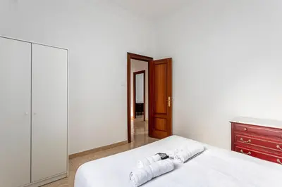 a bedroom with a white bed and a dresser at Guest Ready - Bright flat well‑located urban stay in Valencia