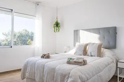 a white bedroom with a large bed with towels on it at Origen Tepoztlán Relájate en un lugar encantador in Torrent