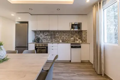 a kitchen with white cabinets and a wooden table at Monte Taxco Escapada perfecta en un entorno único in Torrent